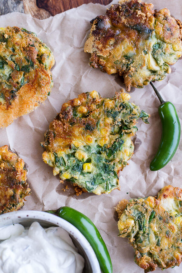 SKILLET CORN FRITTERS WITH SPINACH AND HONEY Jalapeño CREAM.